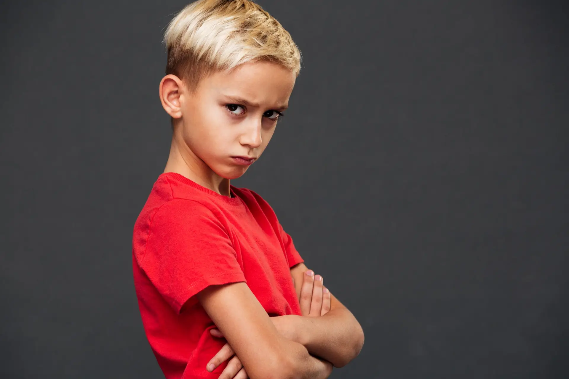 angry little boy child with arms crossed scaled